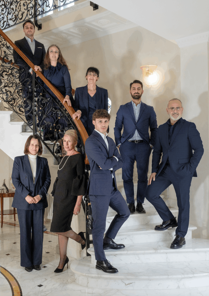 Foto del team di Case & Casali posizionato su una scalinata elegante in abiti professionali